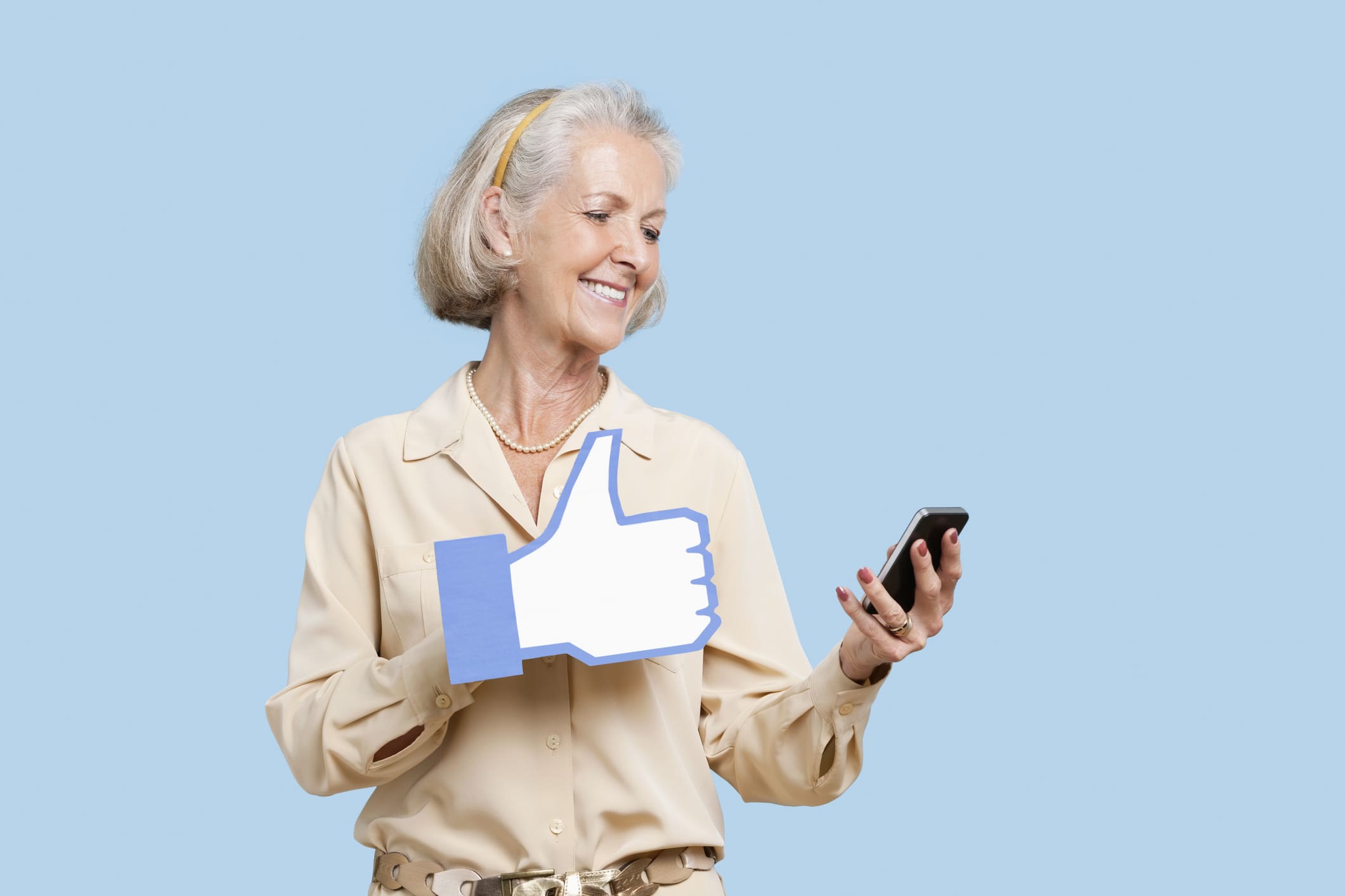 Senior woman with cell phone holding like button